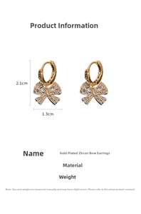 Detail view of gold-plated zircon bow earrings showing 2.1cm height and 1.3cm width dimensions