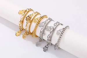 Detail of Hamsa Hand pendants on layered gold and silver chains for women jewelry