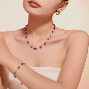 Detail shot of bohemian purple crystal necklace and bracelet set worn by a model