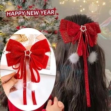 Detail of red velvet bow hair clip with star diamond buckle and white plush pom-poms