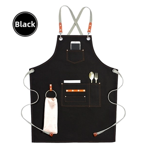 Detail of heavy-duty black canvas apron with multi-pockets, leather loops, and accessories