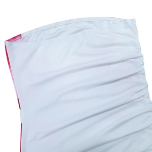 Detail of white ruched fabric texture on a slim-fit strapless dress with side slit