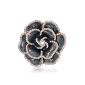 Detail view of camellia brooch with grey marble petals, pearls, and golden base