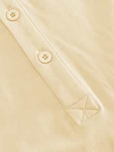 Detailed macro view of placket stitching and beige four-hole buttons on men's polo shirt
