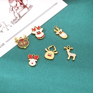 Macro detail of six enamel reindeer charms for DIY jewelry on a festive background