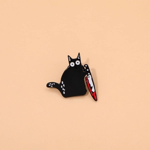 Detailed view of creative black cat enamel pin holding a bloody knife accessory