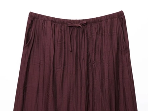 Detail of burgundy pleated skirt with elastic waistband and adjustable drawstring knot