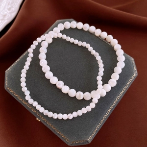 Elegant geometric faux pearl stretch bracelets in two bead sizes on velvet tray