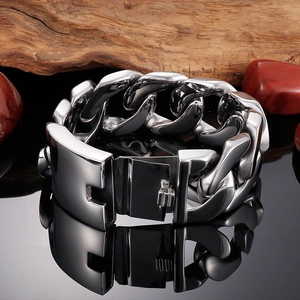 Macro detail of silver stainless steel Cuban link bracelet with square safety clasp