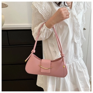 Pink PU leather shoulder bag with gold buckle worn by model in white lace dress