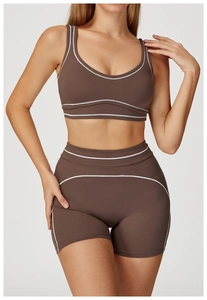 Detailed close-up of dark brown yoga set featuring white contrast stitching and ribbed texture