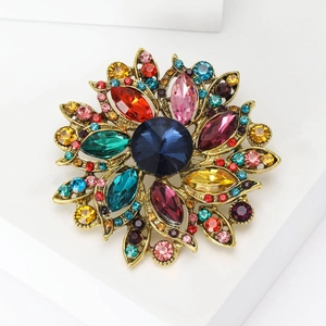 Macro detail of a vintage floral brooch with colorful crystals and an antique gold base