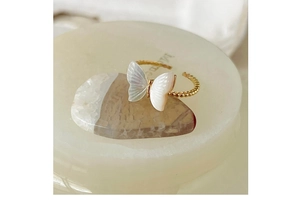 Detailed view of adjustable gold butterfly ring featuring white mother-of-pearl wings