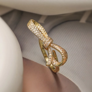 Luxurious 18K gold plated bow ring with sparkling cubic zirconia on a soft fabric backdrop