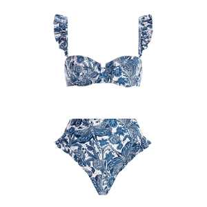 Flat lay of blue floral bikini set with ruffle straps and high-waisted bottoms on white background