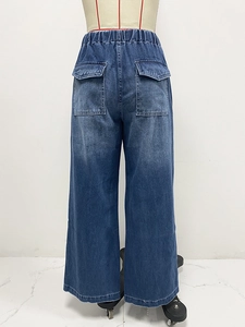 Detail view of deep blue washed denim jeans with elastic waist and back flap cargo pockets