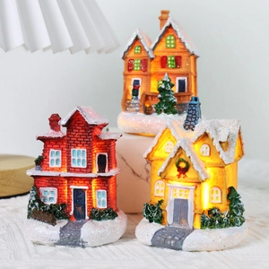 Three LED lighted Christmas resin houses with artificial snow and warm yellow glow