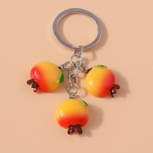 Close-up of realistic persimmon charms in red and yellow on a silver metal keychain