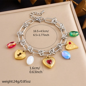 Detail view of gold charm bracelet showing multi-color gemstones and precise measurements