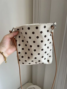 Close-up of retro polka dot corduroy crossbody bag with adjustable shoulder strap