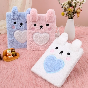 Detailed view of colorful plush unicorn notebooks in pink, blue, and white fuzzy fabric