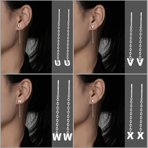 Detail of S999 silver tassel earrings showing letter charms U, V, W, X in macro view