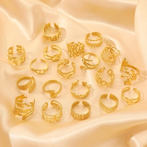 Set of minimalist gold titanium steel adjustable rings displayed on elegant champagne satin