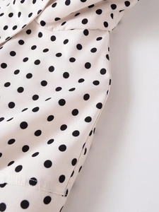 Detalle de tela blanca con lunares con costuras finas y detalles del cuello