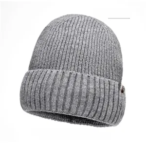 Detail of light gray chunky knit beanie with premium brown leather label accent