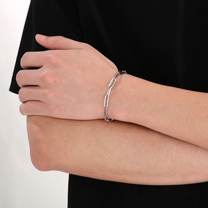 Detail view of a silver titanium steel rectangular link chain bracelet worn on a wrist