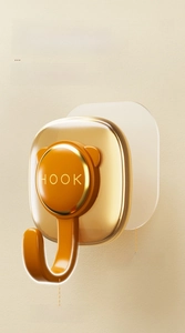 Detail of strong adhesive wall hook with deep metal ring and warm orange finish