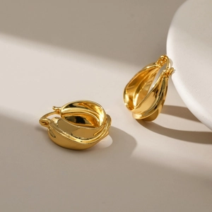 Polished gold irregular twisted hoop earrings with a textured wavy petal design
