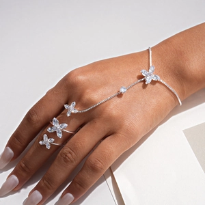 Vista dettagliata di un set bracciale-anello con fiori in zircone argento sulla mano