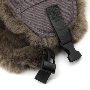 Detailed close-up of winter trapper hat showing thermal faux fur lining and buckle strap