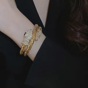 Elegant gold snake bracelet with cubic zirconia paving worn by a model on black outfit