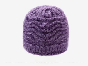 Dettaglio del berretto in maglia viola con motivo a onde e bordo a costine sul retro