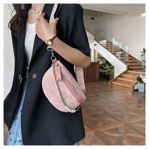 Detail of pink crescent bag showing pearl chain and wavy texture shoulder strap