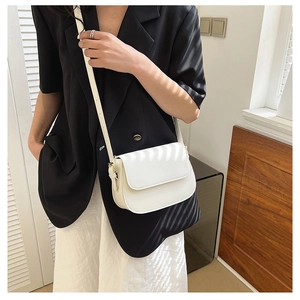 White minimalist PU leather flap crossbody bag worn by a model in black blazer style