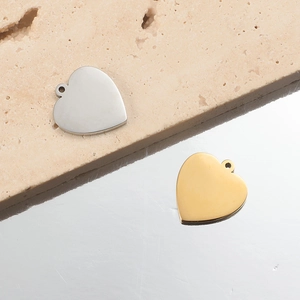 Polished stainless steel heart-shaped pendants in gold and silver on stone