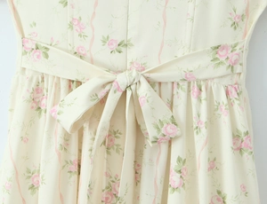 Dettaglio del punto vita del vestito con stampa floreale rosa e un fiocco abbinato