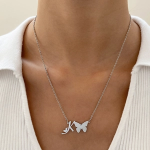 Dettaglio del ciondolo a farfalla e lettera K in argento su collana in acciaio inox