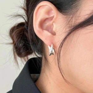S925 sterling silver knotted geometric hoop earrings worn by a model in a close-up view