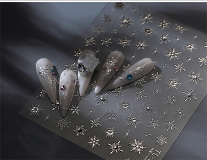 Macro detail of 3D silver snowflake nail art stickers with sparkling crystal diamond accents