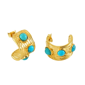 Détail de boucles d'oreilles dorées en C avec texture ondulée et trois pierres turquoises