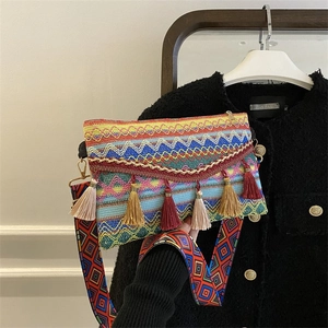 Detail of bohemian woven crossbody bag with colorful patterns and fringe tassels
