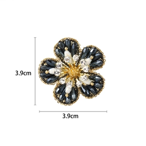 Detailweergave van bloembloche met blauwe kralen en witte parels, afmeting 3,9 cm bij 3,9 cm