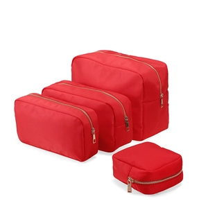 Set of four red nylon cosmetic bags in various sizes with durable zipper closure