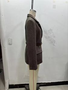 Detailed side view of dark brown herringbone blazer featuring a waist belt and flap pocket