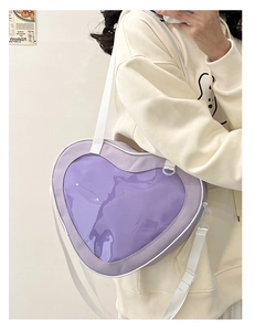 Detail view of purple heart-shaped window bag with white canvas strap worn by a model