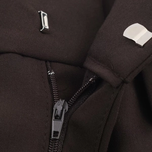 Détail d'un pantalon marron foncé avec fermeture éclair métallique et crochet de taille